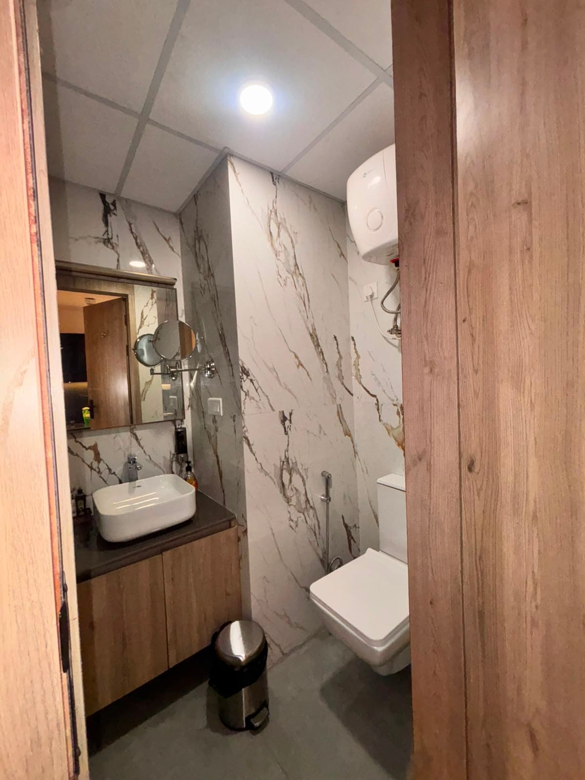 Marble en-suite bathroom with vanity basin, mirror and water heater